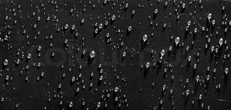 Waterdrops on black scratched surface, stock photo