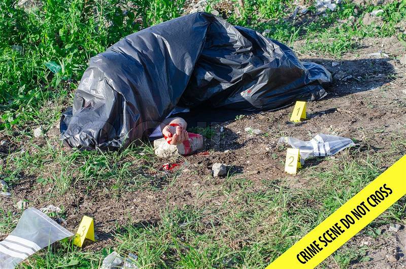 Crime scene with male corpse and evidence markers, stock photo