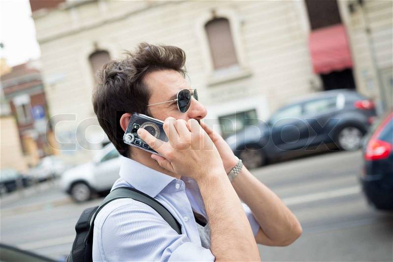 Man in the street on the phone in the morning, stock photo