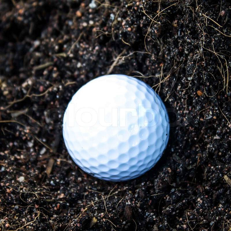 Golf ball on a tee against the golf course with copy space, stock photo