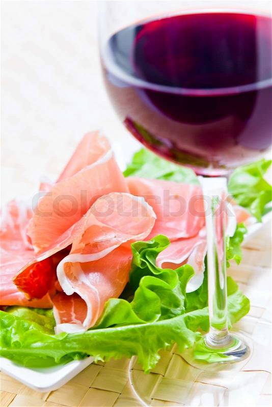Glass with red wine and ham with salad , stock photo