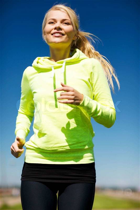 Fitness and lifestyle concept - female runner jogging outdoors, stock photo