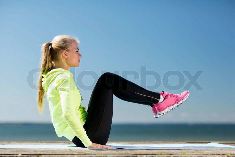 Fitness and lifestyle concept - woman doing sports outdoors, stock photo
