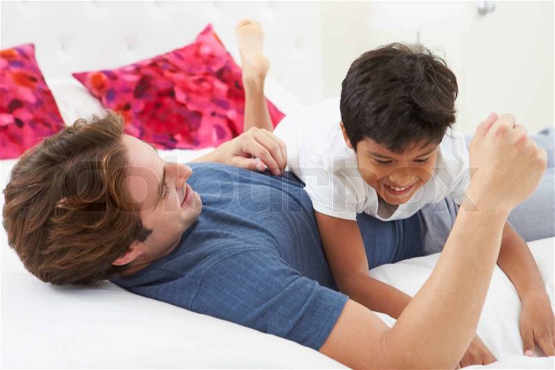 Father And Son Playing In Bed Together, stock photo