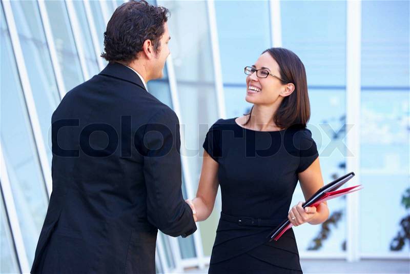Businessman And Businesswomen Shaking Hands Outside Office, stock photo