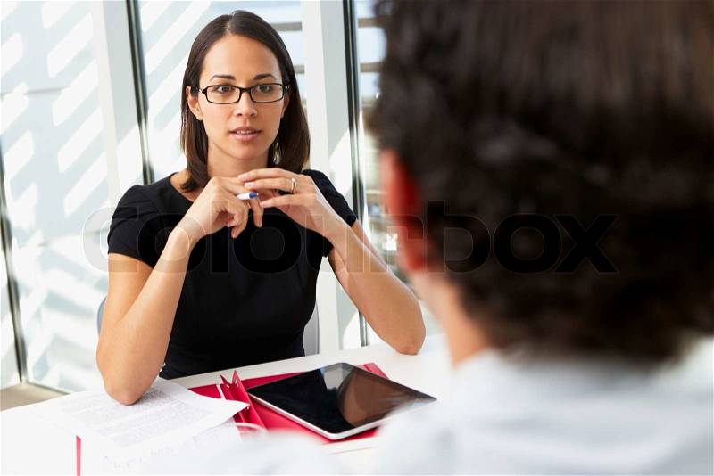 Businesswoman Interviewing Male Candidate For Job, stock photo