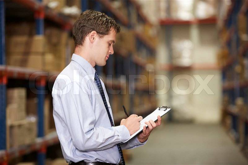 Manager In Warehouse With Clipboard, stock photo