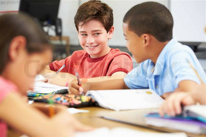 Pupils Studying At Desks In Classroom, stock photo