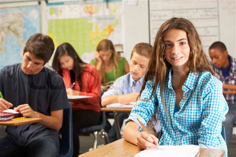 Portrait Of Female Pupil Studying At Desk In Classroom, stock photo