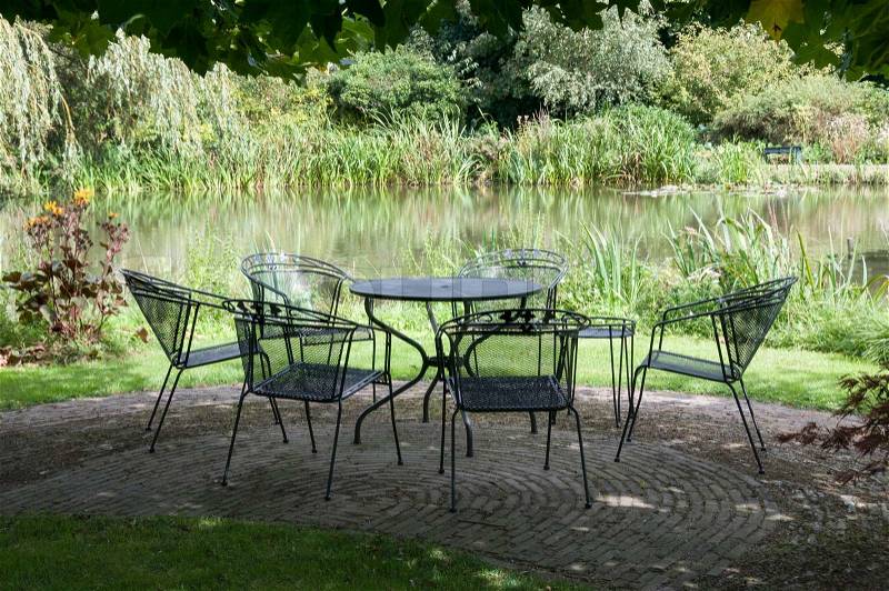 Green park with metal chairs and table garden furniture, stock photo