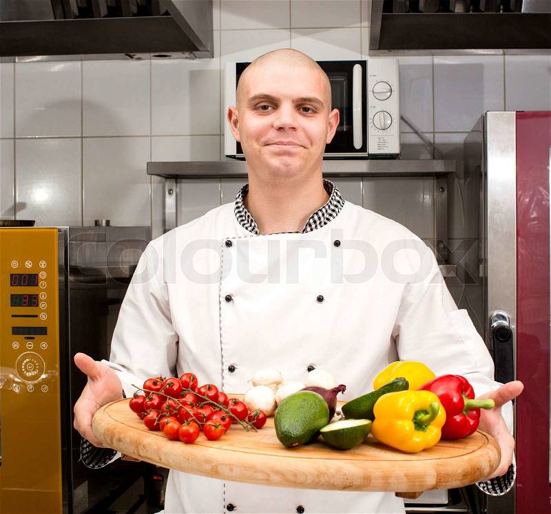 Chef preparing food in the kitchen at the restaurant, stock photo