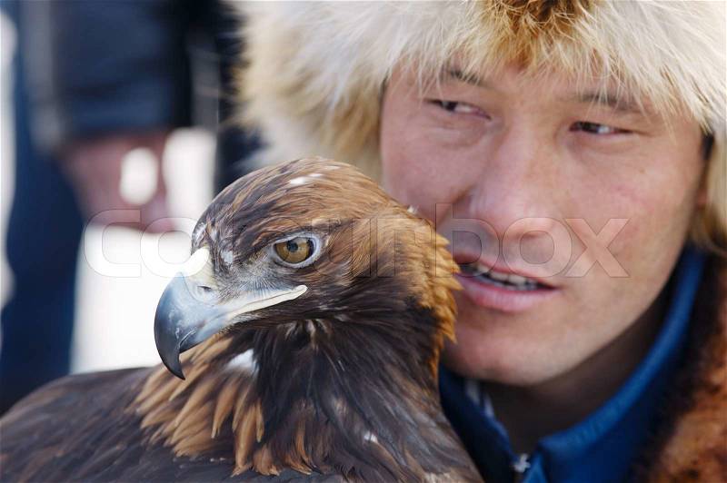 NURA, KAZAKHSTAN - FEBRUARY 23: Eagle on man's hand in Nura near Almaty on February 23, 2013 in Nura, Kazakhstan. The traditional event happens yearly and the place becomes as a medieval times city, stock photo
