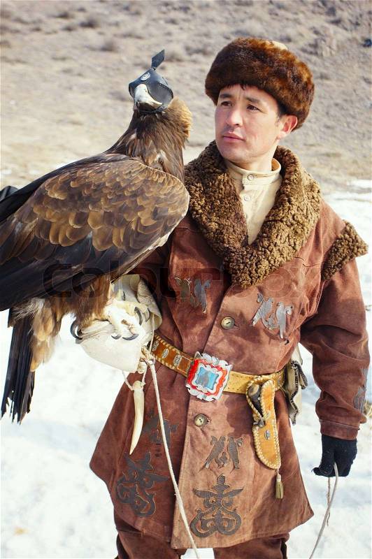 NURA, KAZAKHSTAN - FEBRUARY 23: Eagle on man\'s hand in Nura near Almaty on February 23, 2013 in Nura, Kazakhstan The traditional event happens yearly and the place becomes as a medieval times city, stock photo