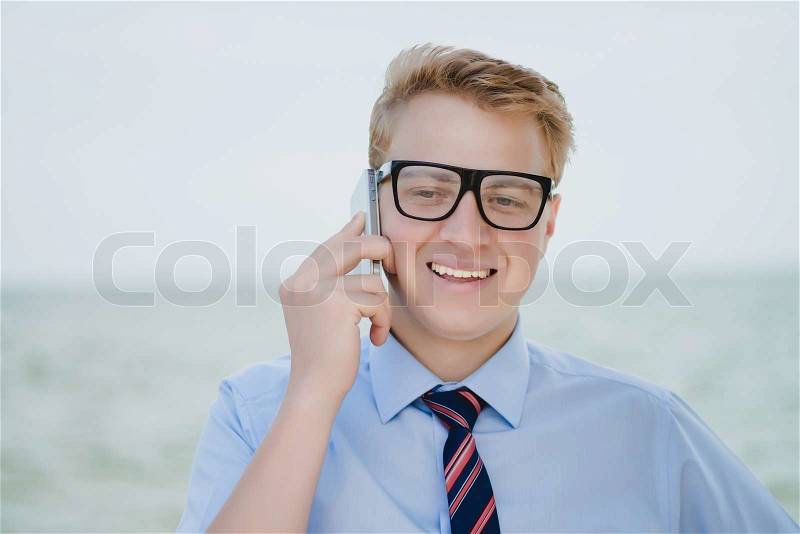 Successful young businessman with phone, stock photo