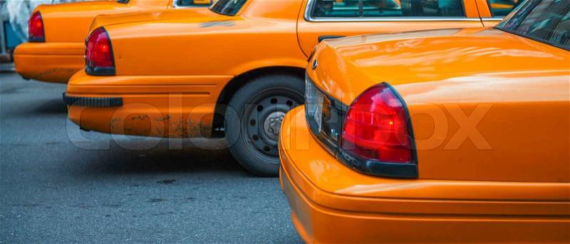 Row of Yellow Cabs awaiting the traffic light green signal in the streets of Manhattan - New York City, stock photo