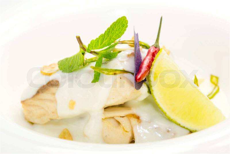 Baked fish in cream sauce with lemon, stock photo