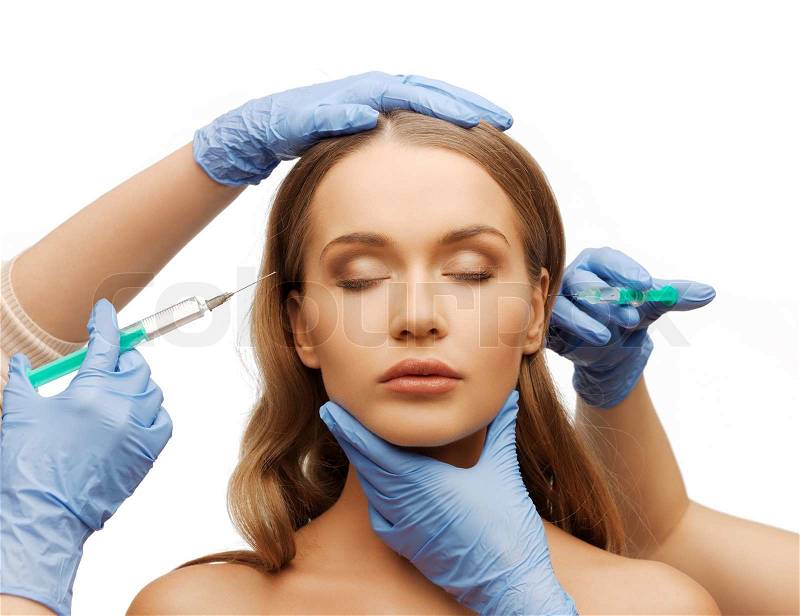 Cosmetic surgery concept - woman face and beautician hands with syringes, stock photo
