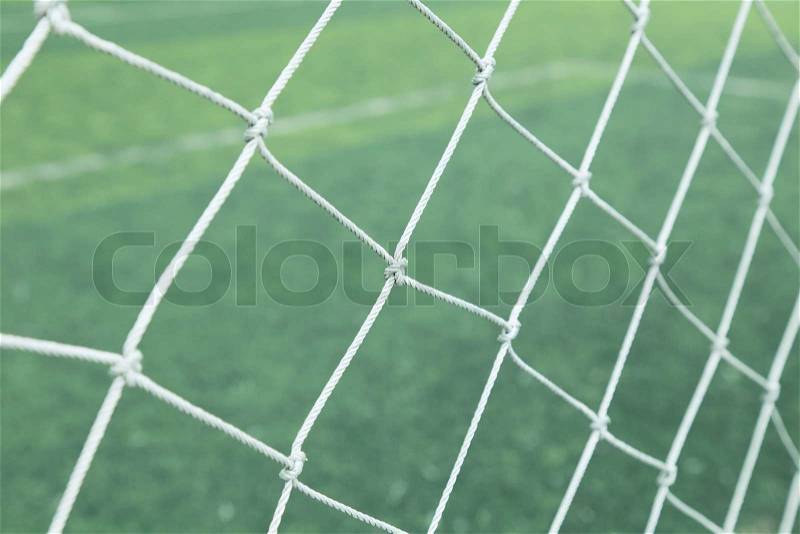 Background of football net on a green grass, stock photo