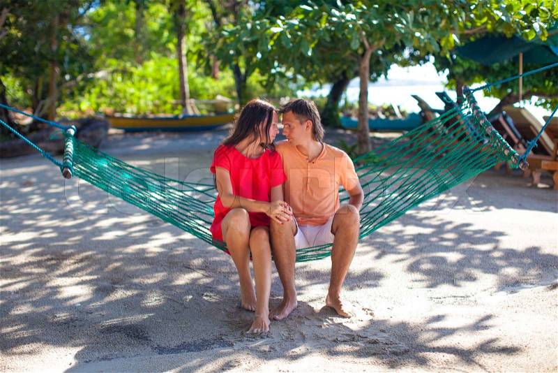 Young loving couple in a hammock in exotic resort, stock photo