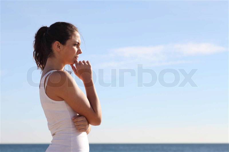 Beautiful woman thinking and watching in front the sea, stock photo