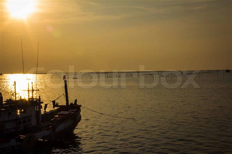 Fishing boats anchored in the sea, floating peacefully in the evening, stock photo
