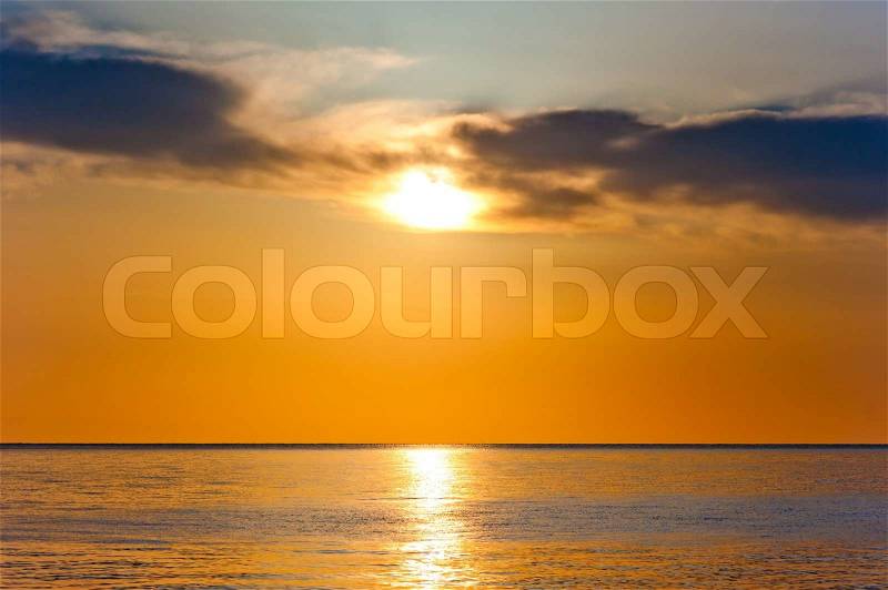 Sunset in orange tones over a calm sea, stock photo