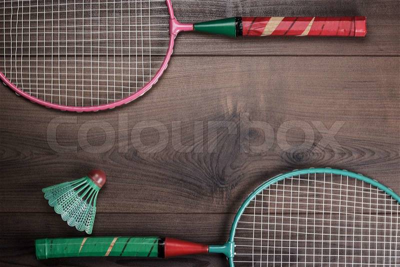 Shuttlecock and badminton rackets on wooden background, stock photo