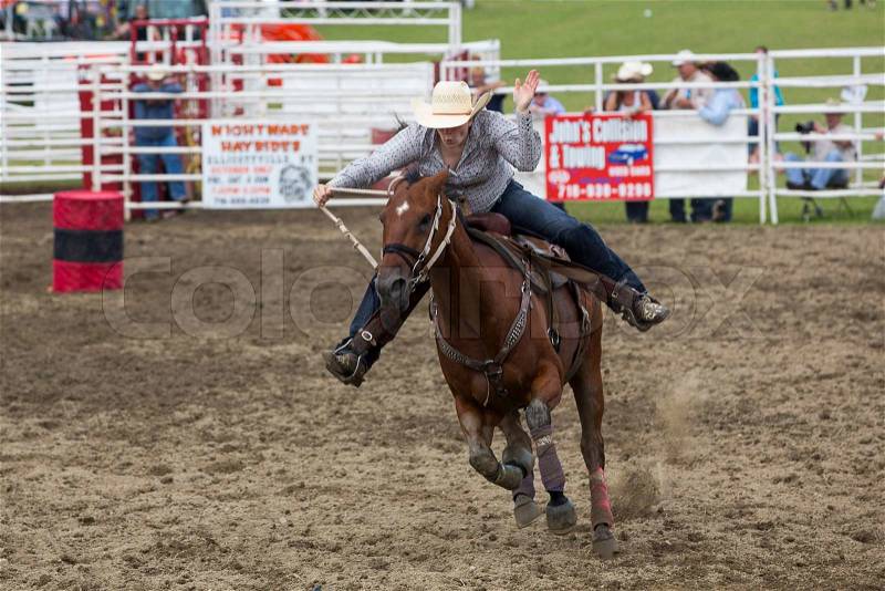 Ellicottville, NY – July 7: A cowboy bronco rider hangs on his horse at the competition in Ellicottville Championship Rodeo on July 7, 2013 in Ellicottville, New York. , stock photo