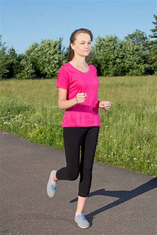 Slim brunette woman running in park, stock photo