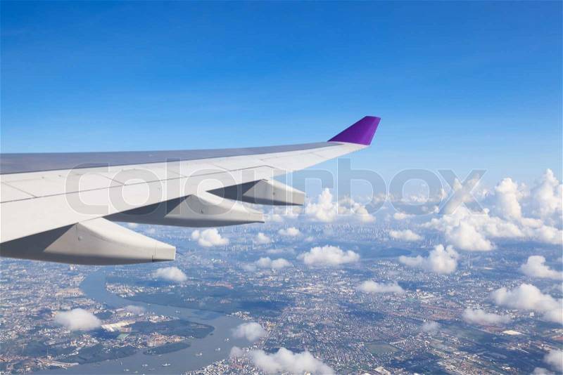 Wing of an airplane flying above the clouds. people looks at the sky from the window of the plane, using air transport to travel, stock photo