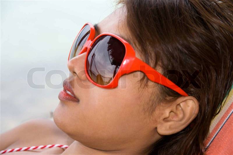 Young woman resting on deck chair, stock photo
