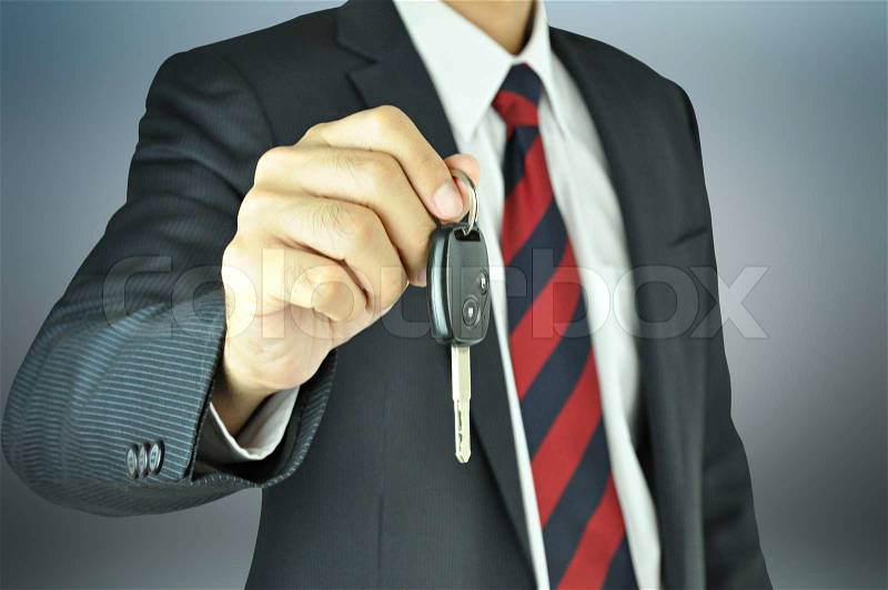 Businessman giving a car key, stock photo