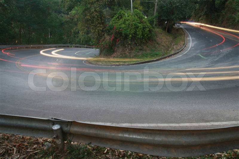 Sharp curve road with car light line, stock photo