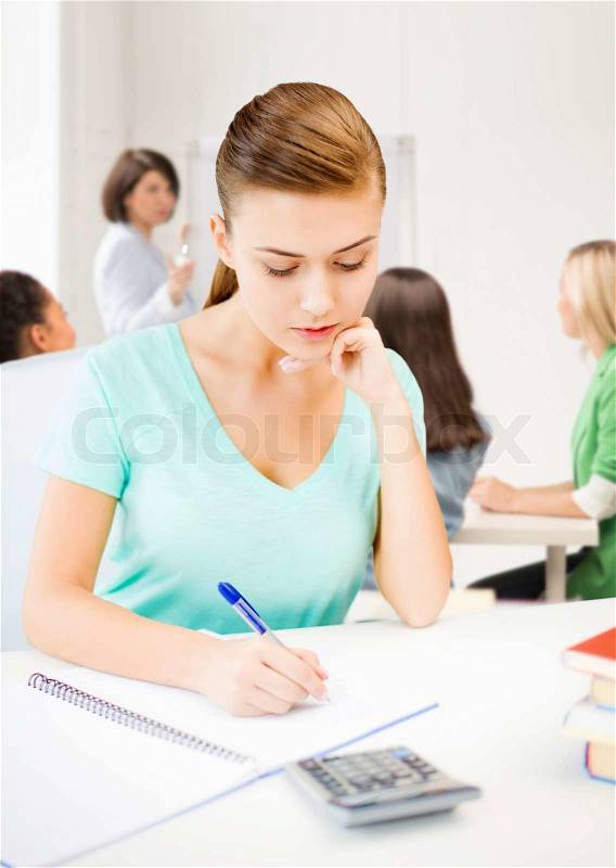 Education concept - student girl with notebook and calculator, stock photo