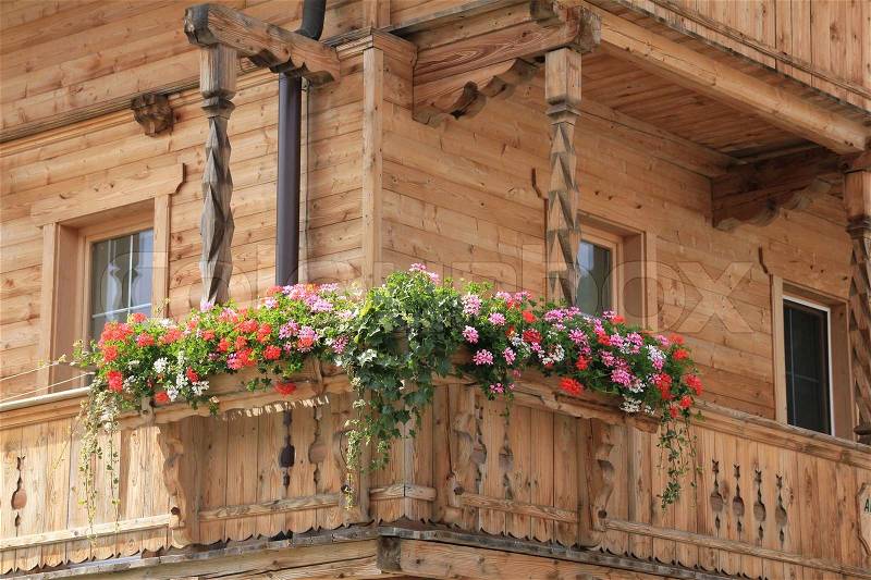 Red, white and pink blooming geraniums in flower boxes on the balcony in the beautiful summer, stock photo