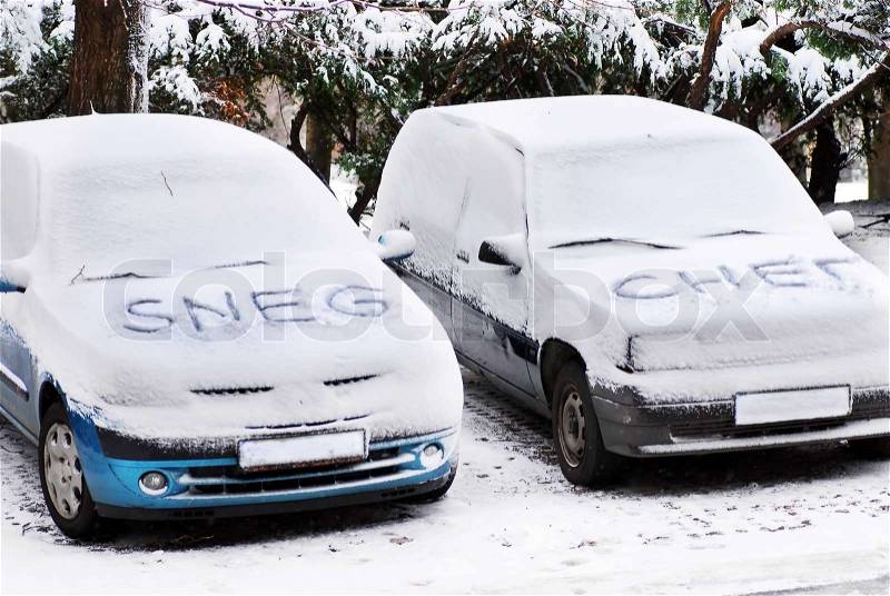 Serbian latin and cyrillic letters written on automobiles covered by snow at winter outdoors, stock photo