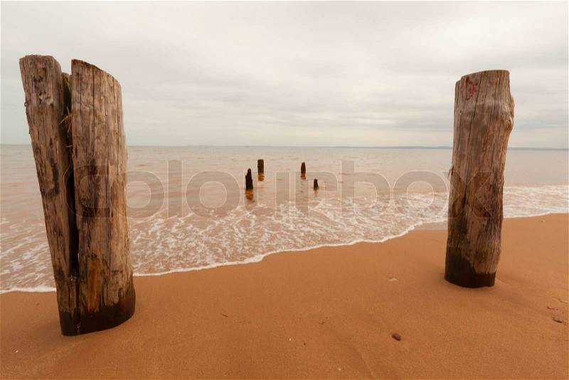 Man made structures and pillars on the sandy beach, stock photo