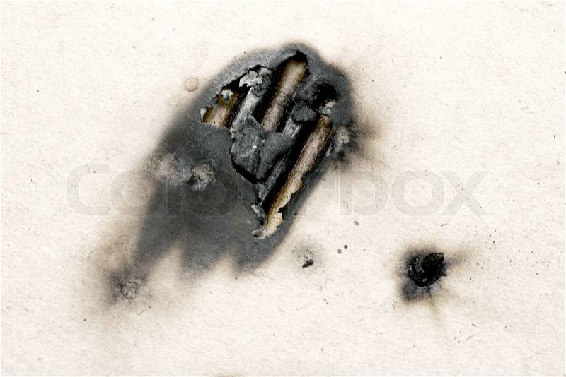 Collection of burnt holes in a piece of paper, stock photo