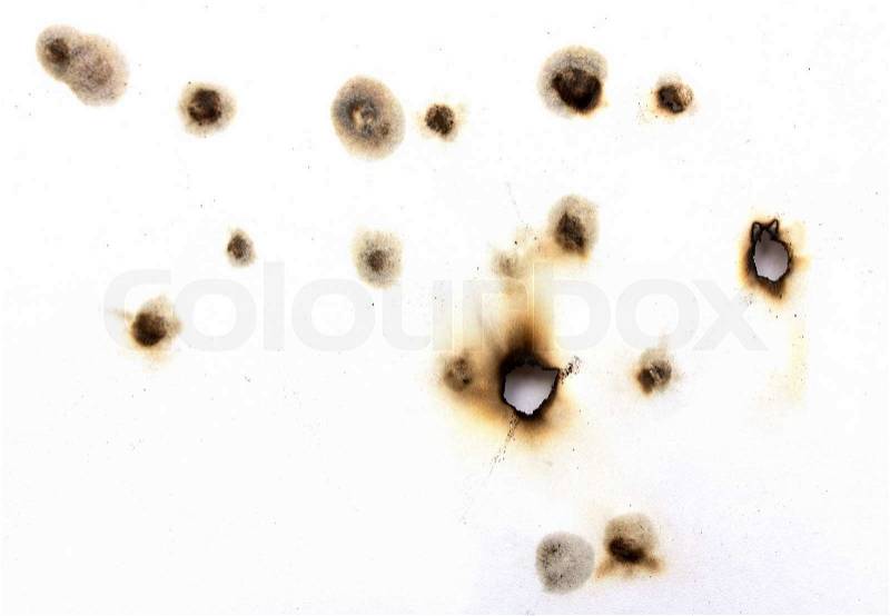 Collection of burnt holes in a piece of paper, stock photo