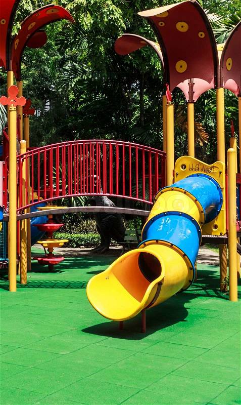 Colorful Spiral Tube Slide with Green Elastic Rubber Floor for Children in the Park, stock photo