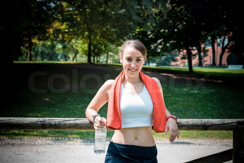 Beautiful woman fitness relaxing after sport at the park, stock photo