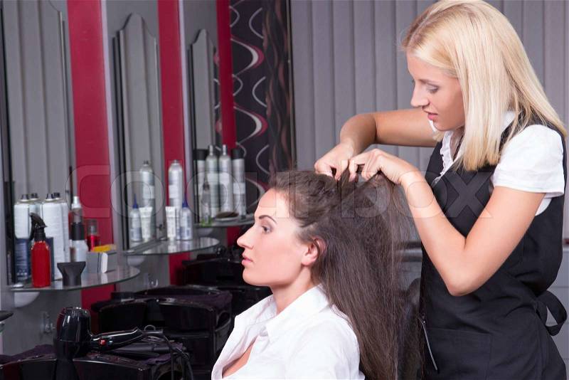 Portrait of professional female hairdresser working in beauty salon, stock photo