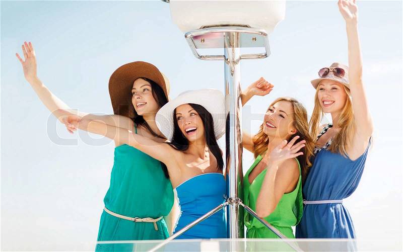 Summer holidays and vacation concept - girls waving on boat or yacht, stock photo