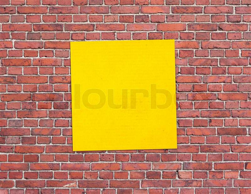 Yellow sticker paper note on brick wall background, stock photo