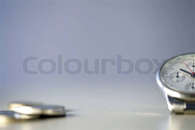 Time and Money - close up photo of one clock and some euro coins, stock photo