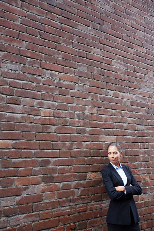 Woman by brick wall, stock photo
