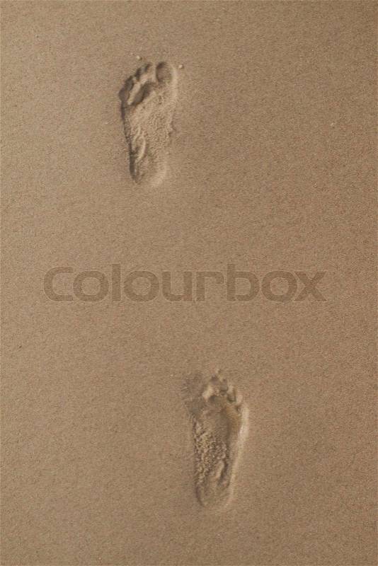 Two human footprints in wet sand, stock photo