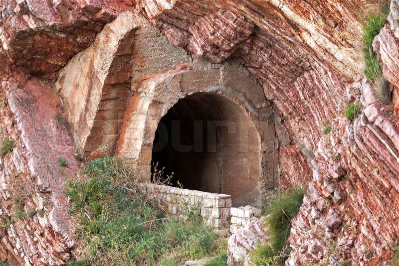 Old tunnel portal in red rock, stock photo