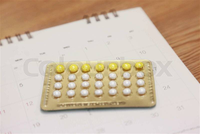 Birth control pills on a calendar, stock photo
