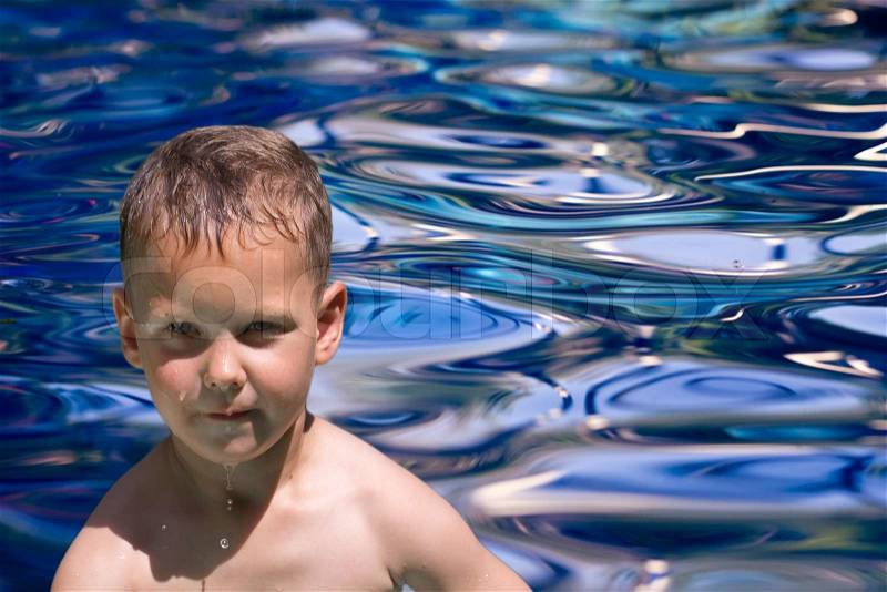 Boy out of the blue water, stock photo